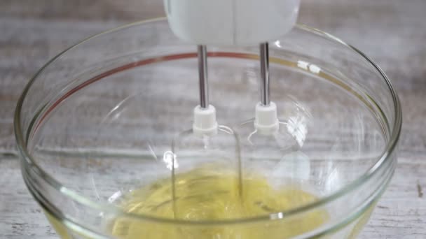 Verte tojást fehérjék az üveg tálba. Folyamat a korbácsolás fehérjék a keverő tálba elektromos keverővel. - Felvétel, videó
