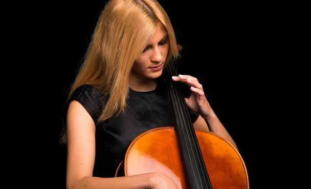 Jovem tocando violoncelo em fundo preto isolado
 - Foto, Imagem