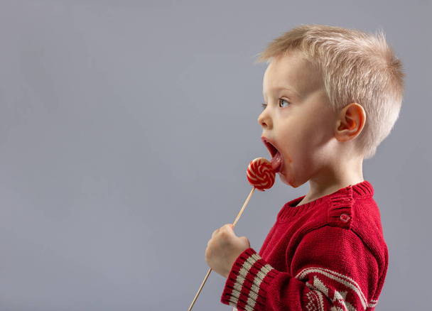 Cute little boy eating a Lollipop close up. - Foto, imagen