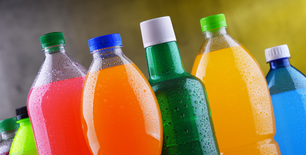 Plastikflaschen mit verschiedenen kohlensäurehaltigen Limonaden in verschiedenen Farben - Foto, Bild