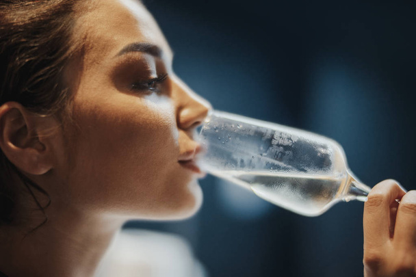 Mujer joven bebiendo champán espumoso con burbujas en el restaurante
. - Foto, Imagen