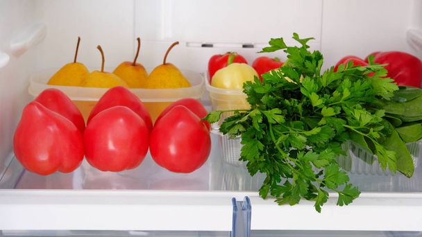 Open fridge. Healthy raw vegetarian food cucumbers, tomatoes, pepper, pears, parsley. Vegetables on shelf of refrigerator. Raw diet concept. - Zdjęcie, obraz