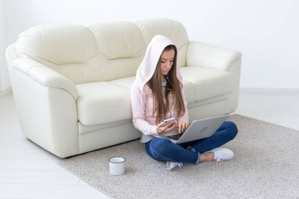 Koncepcja freelance i ludzie - młoda kobieta siedzi na podłodze i pracę na laptopie - Zdjęcie, obraz