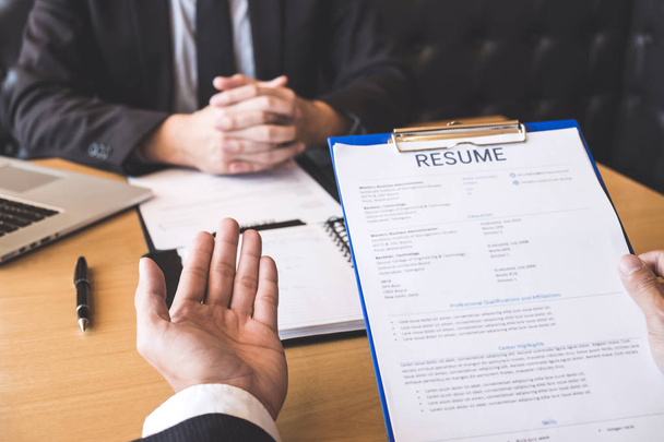 Employer or recruiter holding reading a resume during about his profile of candidate, employer in suit is conducting a job interview, manager resource employment and recruitment concept. - Valokuva, kuva