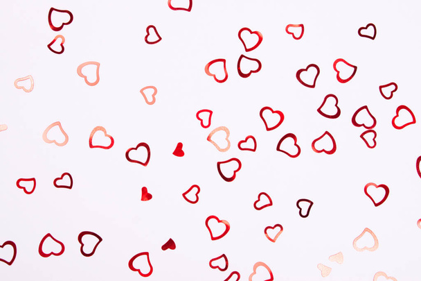 Heart-shaped red confetti on white background. Festive and celebration, Valentine's Day concept. Love symbols. - Fotografie, Obrázek