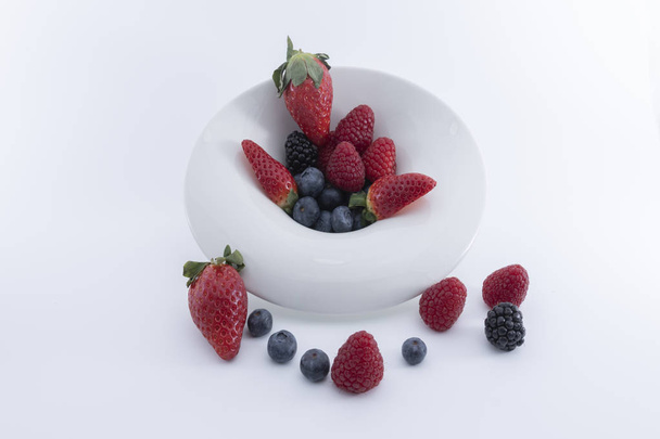 Свіжі ягоди на білий блюдо на білому тлі. -Можу Imagen - Фото, зображення