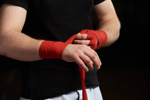 Sportman aplicando vendaje de boxeo a mano
 - Foto, Imagen