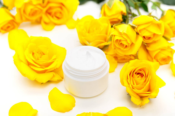 Aromatic botanical cosmetics. Skincare home spa treatment with yellow petals, rose blossom, natural face cream - Photo, Image