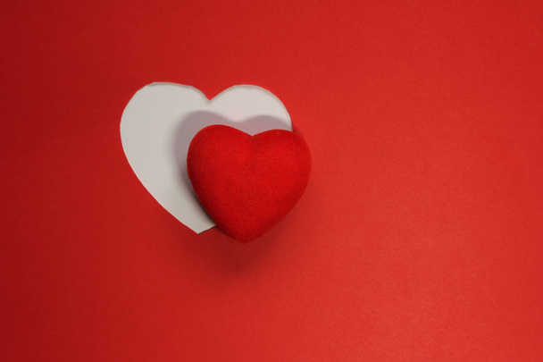 Červené pozadí papíru pro návrh na Valentýna. Dekorační srdce z červené plsti. Pohled shora. Valentines Day koncept - Fotografie, Obrázek