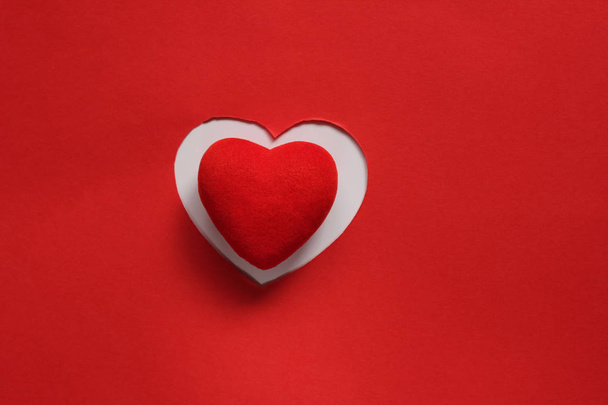 Fondo de papel rojo para el diseño del Día de San Valentín. Corazón decorativo de fieltro rojo. Vista desde arriba. Concepto de San Valentín
 - Foto, Imagen