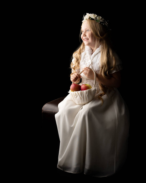 Little girl with a basket of apples. - Fotoğraf, Görsel