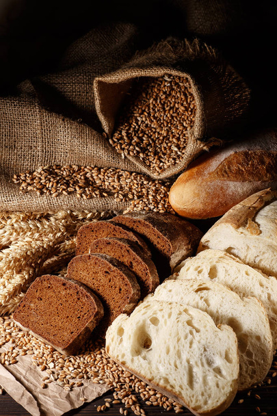 Assortiment gebakken brood op houten tafelondergrond - Foto, afbeelding