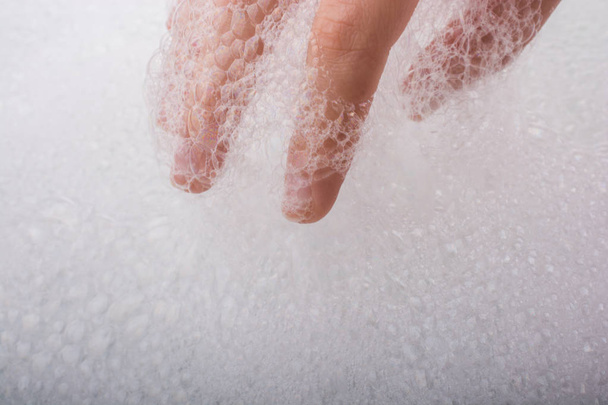 Kézmosás és szappanhab habos háttérrel - Fotó, kép