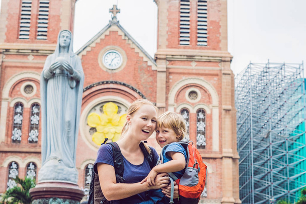 Mom and son in the background Notre dame de Saigon Cathedral, build in 1883 in Ho Chi Minh city, Vietnam - Foto, Imagen