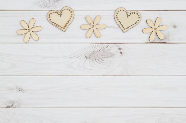 Old fashion love background with wooden hearts and flowers on weathered wood with copy space for your message - Photo, Image