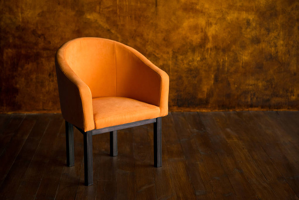 Orange armchair against the background of a brown wall. Interior - Foto, Bild