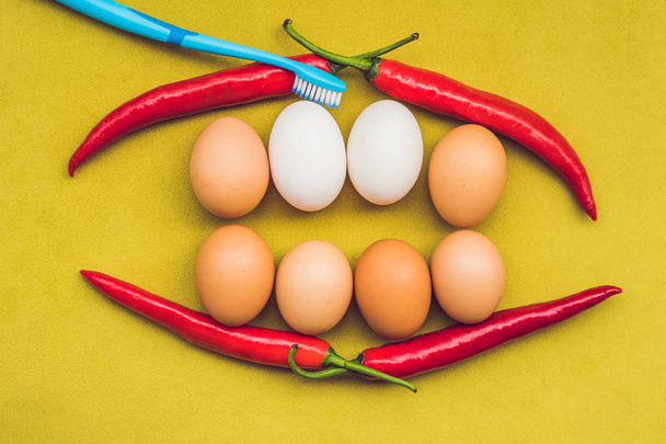 Eggs and red pepper in the form of a mouth with teeth. White eggs are bleached teeth. Yellow eggs - before bleaching. Teeth whitening before and after - Foto, Bild