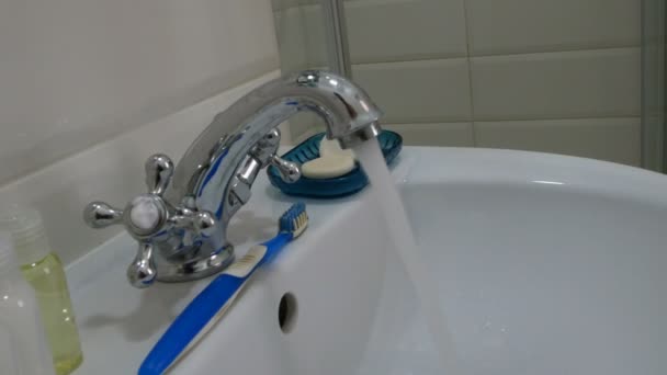 L'acqua pulita scorre dal rubinetto in metallo cromato. Acqua corrente. Rappresenta lo spreco d'acqua. Impianti idraulici per la casa
. - Filmati, video