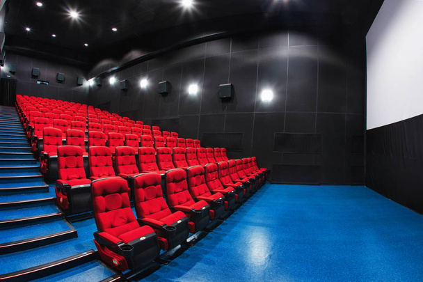 Russia, Nizhny Novgorod - 23 maggio 2014: Mir Cinema. Sedili vuoti nella sala cinema rossa, comode e morbide sedie. Vista auditorium prospettico con spazio bianco sullo schermo
 - Foto, immagini