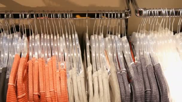 Різні різнокольорові жіночий одяг, що висить на вішалках в магазині одягу в торговому центрі або торговому центрі
 - Кадри, відео
