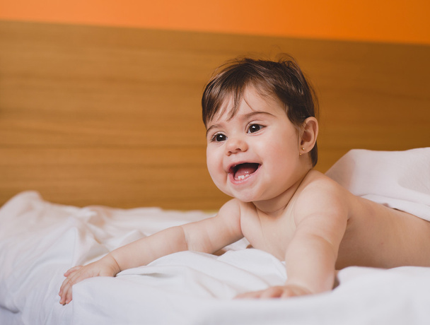 Smiling newborn liying on bed - Photo, Image