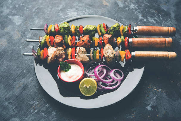 Chicken Hariyali kakab or Malai kebab served with skewers and yogurt dip in a plate. selective focus - Photo, Image
