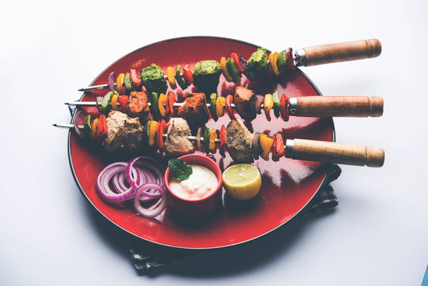 Pollo Hariyali kakab o Malai malai kebab servido con pinchos y salsa de yogur en un plato. enfoque selectivo
 - Foto, Imagen