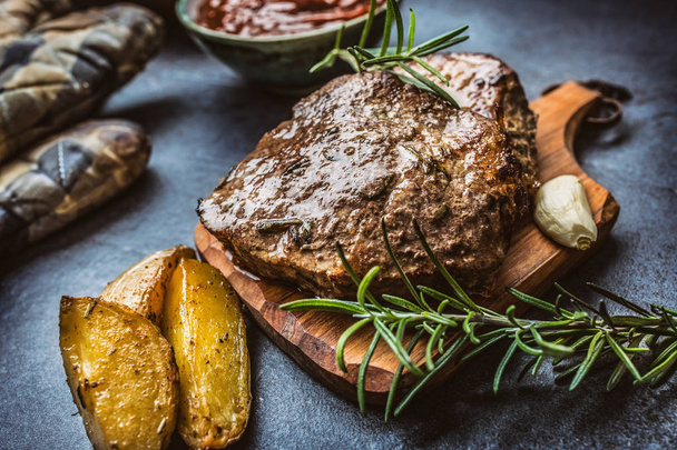 Beef grilled steaks with barbecue sauce roasted potatoes and rosemary. - Фото, изображение