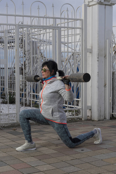 A woman is training outdoor in winter - Foto, afbeelding
