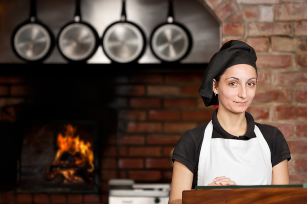 Donna Chef stand in cucina vicino al forno a legna
 - Foto, immagini
