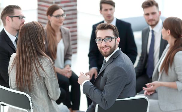 young employee sitting in a circle of colleagues - Foto, imagen