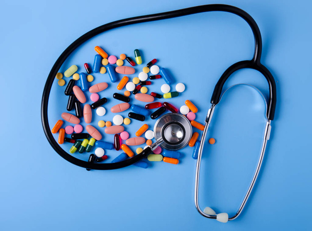 Pills capsules stethoscope medicine health on blue background top view - Φωτογραφία, εικόνα