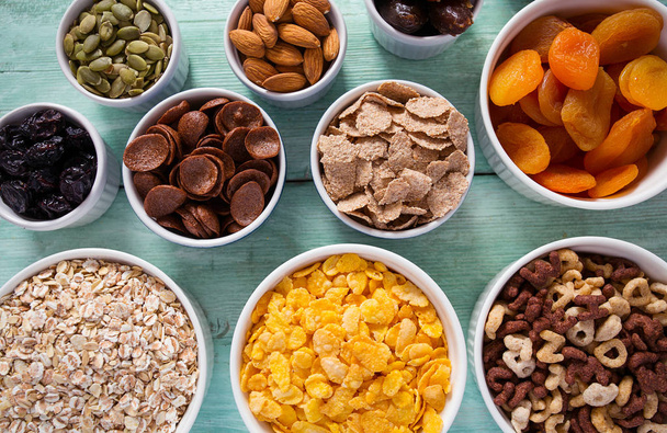 various cereals, nuts and dried fruits on wooden surface - Foto, immagini