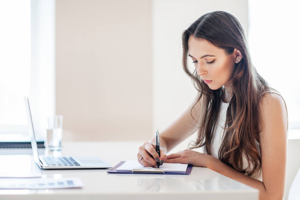 Attractive business woman working in office with documents - Foto, afbeelding