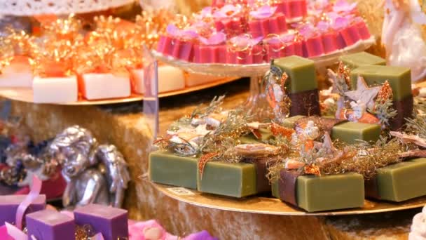 Krásně balené barevné rozmanité ručně vyráběná mýdla na policích různé tvar a velikost na vánoční trh - Záběry, video