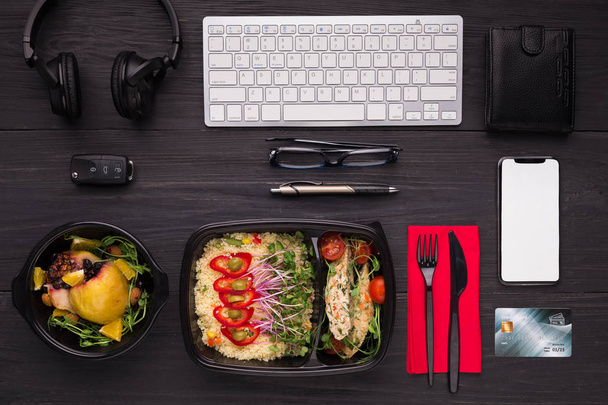 Lunch maaltijden, moderne apparaten en credit card op donkere tafel - Foto, afbeelding