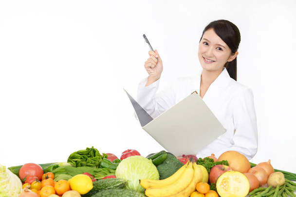 Diététiste agréé souriant aux fruits et légumes
 - Photo, image