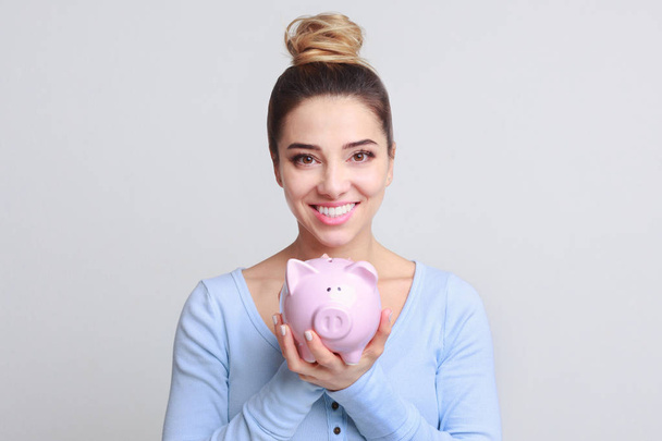 Excited woman with piggy bank on background - Fotoğraf, Görsel
