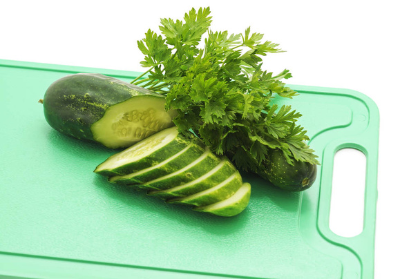Fresh cucumber and parsley on the board on a white background. - Foto, Imagen