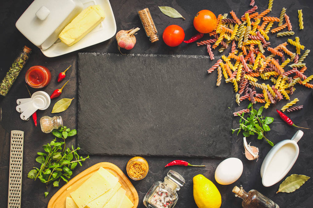 макароны, ингредиенты, томатный соус (шифер на доске). вид сверху. копировальное пространство
 - Фото, изображение