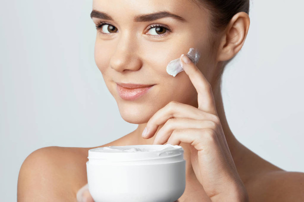 Skincare. Beauty Concept. Young pretty woman holding cosmetic cream - Foto, Imagen