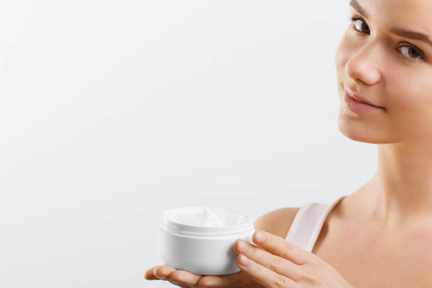 Skincare. Beauty Concept. Young pretty woman holding cosmetic cream - Foto, Bild