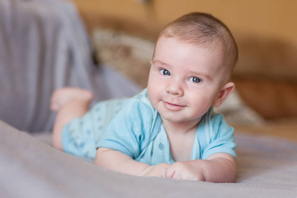 little boy happy baby lying on the sofa and smiling sweetly - Foto, imagen