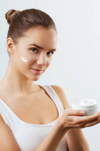 Skincare. Beauty Concept. Young Pretty Woman Holding Cosmetic Cream.Girl wiht fresh skin, antiaging concept.Spa. Beauty Concept. Female with fresh makeup and Perfect Skin - Foto, afbeelding