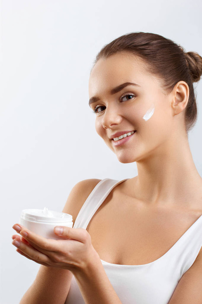 Skincare. Beauty Concept. Young Pretty Woman Holding Cosmetic Cream.Girl wiht fresh skin, antiaging concept.Spa. Beauty Concept. Female with fresh makeup and Perfect Skin - Photo, Image