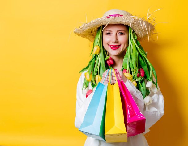 mulher de camisa branca e chapéu com tulipas frescas da primavera e caixa de compras
 - Foto, Imagem