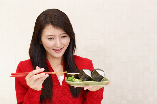 Femme souriante avec des rouleaux de sushi
 - Photo, image