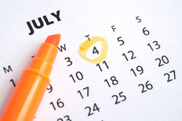 Unabhängigkeitstag. Der vierte Juli wird auf dem Kalender 2019 mit einem orangefarbenen Marker markiert. - Foto, Bild
