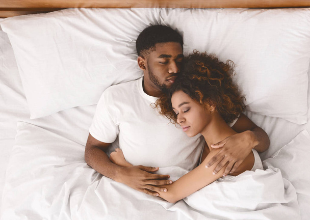 Молодая черная пара спит вместе в постели
 - Фото, изображение