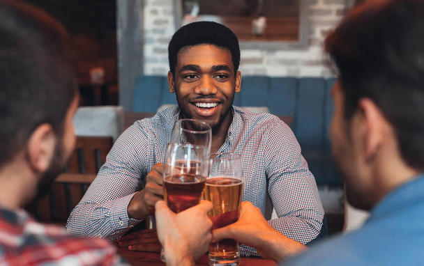Τρεις άνδρες πίνοντας μπύρα, γιορτάζοντας συνάντηση σε bar - Φωτογραφία, εικόνα